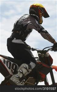 Side profile of a motocross rider riding a motorcycle
