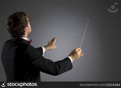 Side profile of a music conductor performing