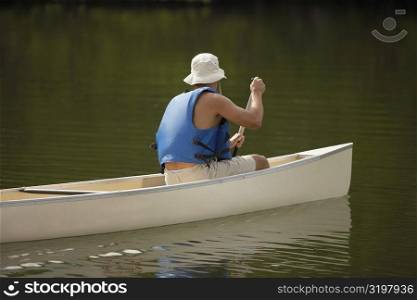 Side profile of a person boating in a river