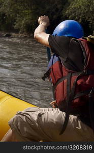 Side profile of a person rafting in a river