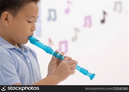 Side profile of a schoolboy playing a flute
