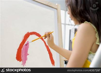 Side profile of a schoolgirl painting in an art class