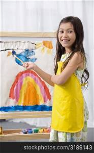 Side profile of a schoolgirl painting in an art class and smiling
