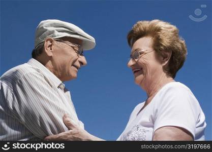 Side profile of a senior couple holding each other and smiling