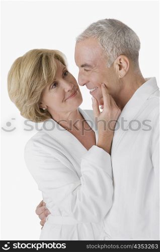 Side profile of a senior man embracing a mature woman and smiling