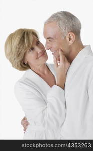 Side profile of a senior man embracing a mature woman and smiling