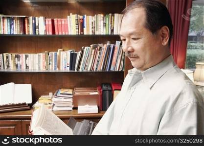 Side profile of a senior man reading a book