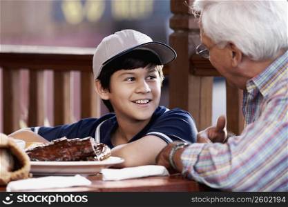 Side profile of a senior man with his grandson at a restaurant