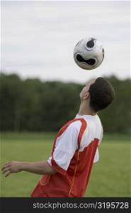Side profile of a soccer player heading a ball