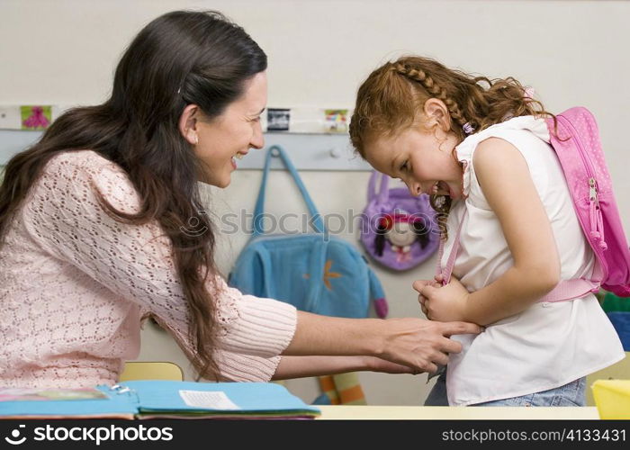 Side profile of a teacher and her student smiling