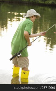 Side profile of a teenage boy holding a fishing rod