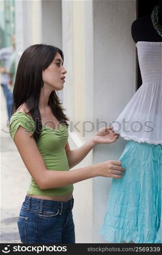 Side profile of a teenage girl at a clothing store