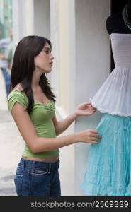 Side profile of a teenage girl at a clothing store