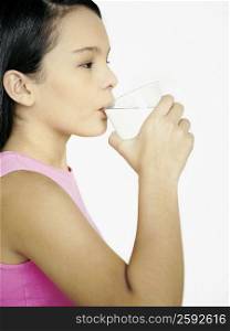 Side profile of a teenage girl drinking water from a glass