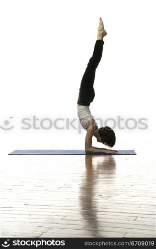 Side profile of a woman doing handstand
