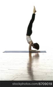 Side profile of a woman doing handstand