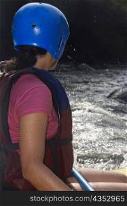 Side profile of a woman rafting in a river