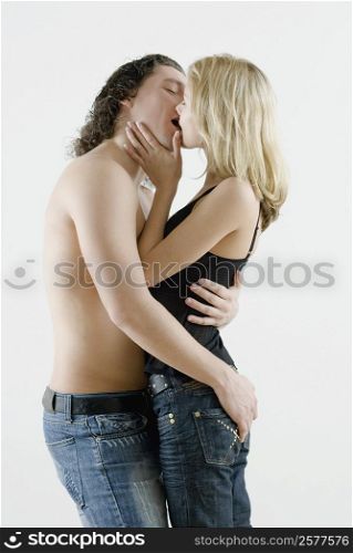 Side profile of a young couple kissing each other