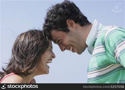 Side profile of a young couple looking at each other and smiling