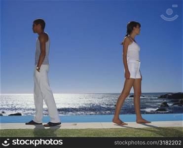 Side profile of a young couple standing by the pool