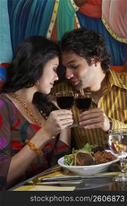 Side profile of a young couple toasting wine in a restaurant