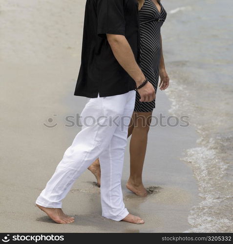 Side profile of a young couple walking on the beach