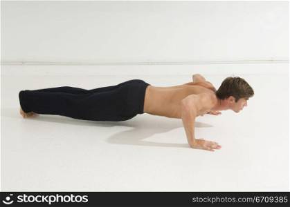 Side profile of a young man doing push-ups