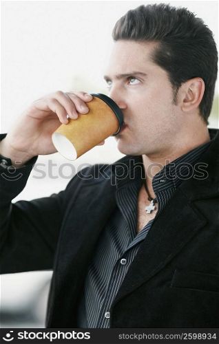 Side profile of a young man drinking coffee