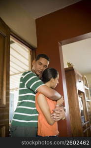 Side profile of a young man embracing a teenage girl