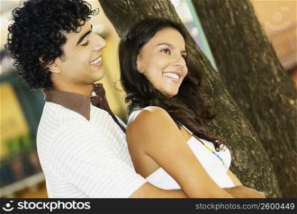Side profile of a young man embracing a teenage girl from behind
