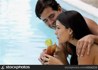 Side profile of a young man giving a sip to a young woman