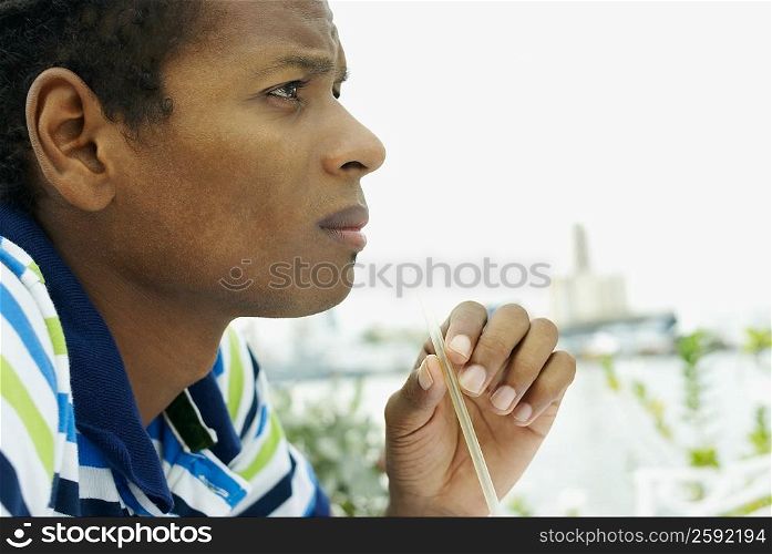 Side profile of a young man holding a drinking straw