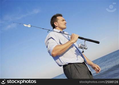 Side profile of a young man holding a fishing rod