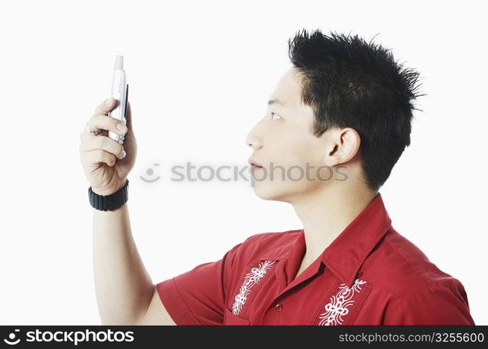 Side profile of a young man holding a mobile phone