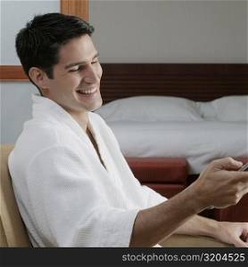 Side profile of a young man holding a remote control and smiling