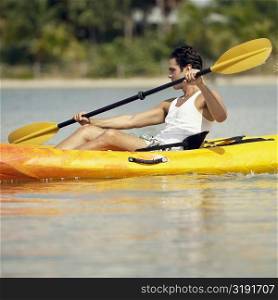 Side profile of a young man kayaking