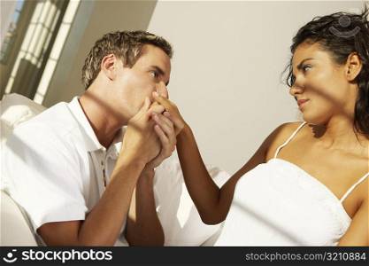 Side profile of a young man kissing a young woman&acute;s hand