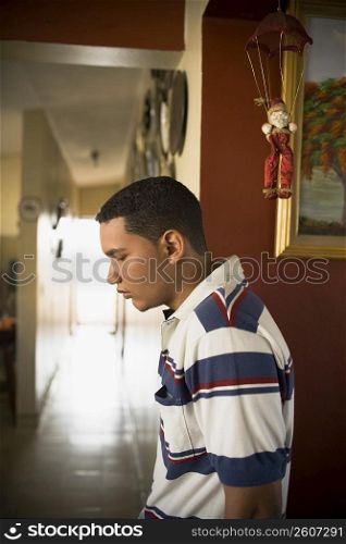 Side profile of a young man looking down and thinking