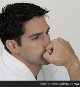 Side profile of a young man looking pensive