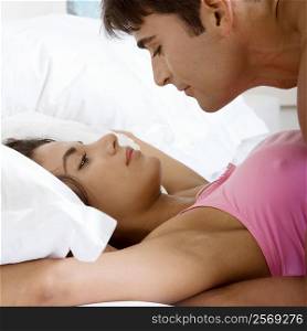 Side profile of a young man lying on top of a young woman