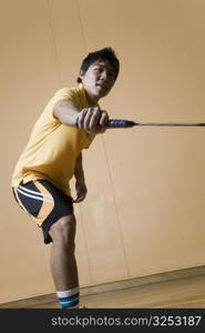 Side profile of a young man playing badminton