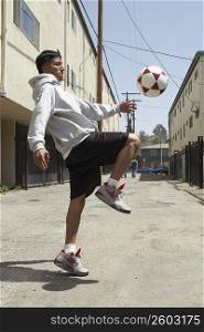 Side profile of a young man playing with a soccer ball
