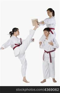 Side profile of a young man practicing kickboxing with two young women