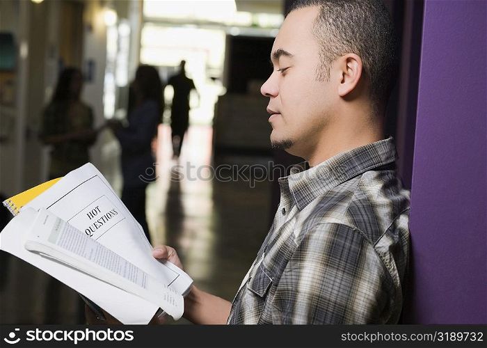 Side profile of a young man reading a book