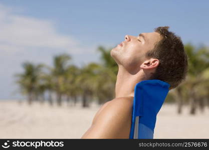 Side profile of a young man relaxing on a lounge chair