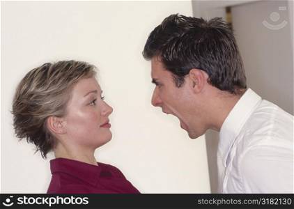 Side profile of a young man shouting at a young woman