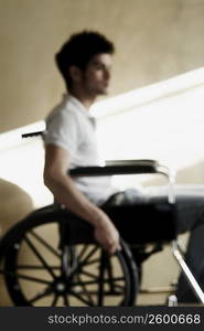 Side profile of a young man sitting in a wheelchair