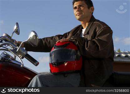 Side profile of a young man sitting on a motorcycle