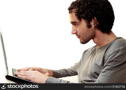 Side profile of a young man using a laptop