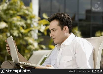 Side profile of a young man using a laptop